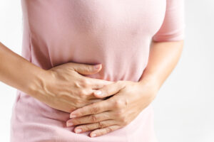 Woman holding her abdomen - feeling sick - in pain.